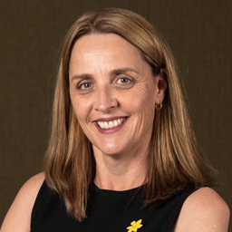 Professor Tanya Buchanan. Woman smiling and wearing yellow Daffodil pin.