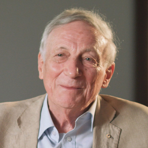 Professor David Hill AO. Man wearing brown jacket and blue shirt.