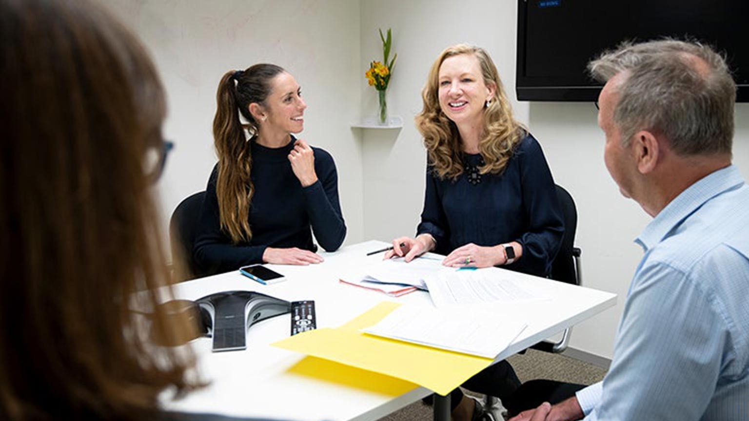 Four people sitting a table talking.